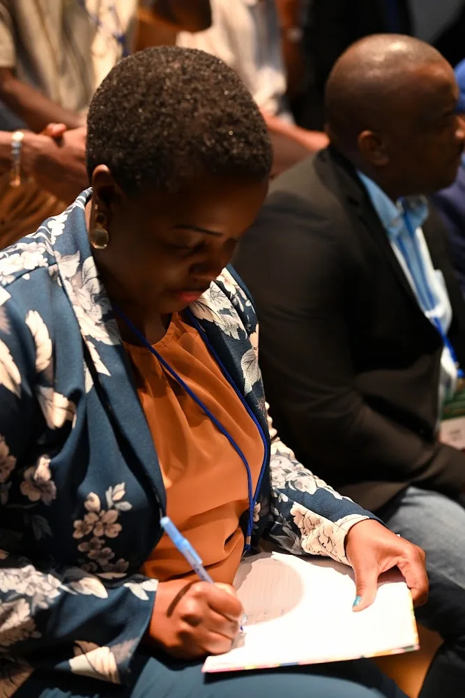 A participant writing notes during a July CI3 signing and reflection moment